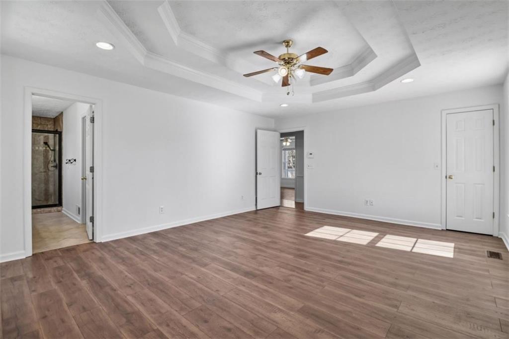 1828 4 Mile Church Road Ball Ground, GA 30107 - Photo 20 of 51 a view of an empty room with wooden floor and a ceiling fan