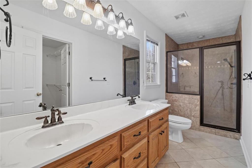 1828 4 Mile Church Road Ball Ground, GA 30107 - Photo 21 of 51 a bathroom with a double vanity sink mirror double and shower
