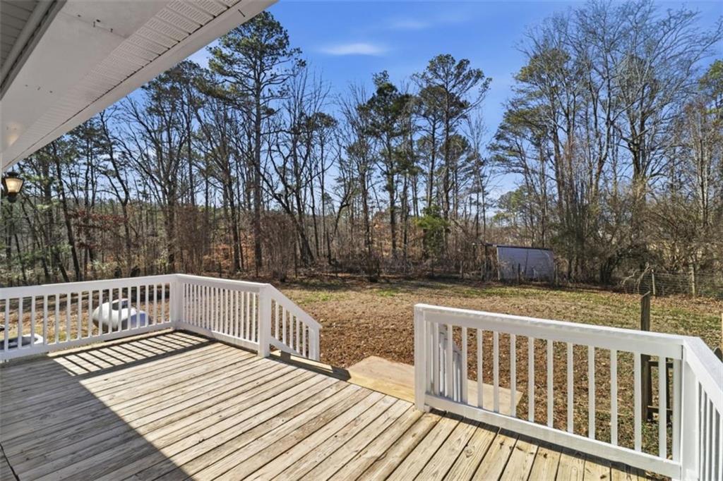 1828 4 Mile Church Road Ball Ground, GA 30107 - Photo 25 of 51 a view of deck with trees and wooden floor