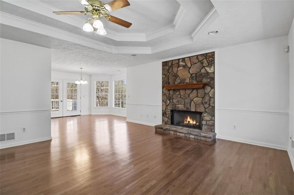 1828 4 Mile Church Road Ball Ground, GA 30107 - Photo 5 of 51 an empty room with wooden floor fireplace and windows