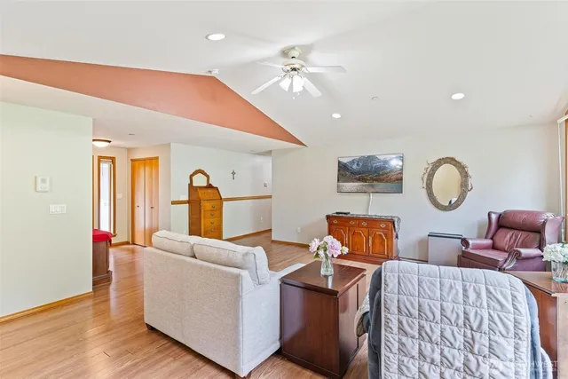 a living room with furniture a mirror and wooden floor