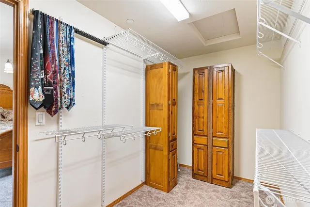 a view of walk in closet with clothes and shoes