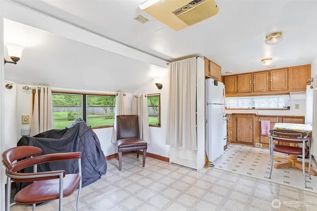 a living room with furniture a large window with kitchen view