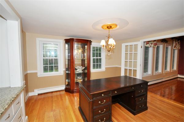 8 Bayberry Road Acton, MA 01720 - Photo 18 of 22 a living room with a stove and a chandelier
