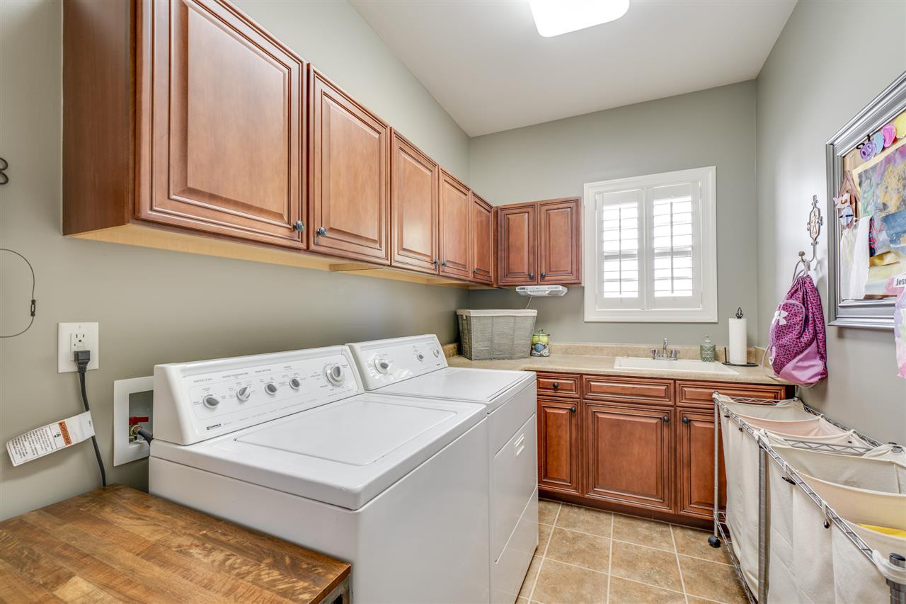 401 Rensford Place Cary, NC 27513 - Photo 12 of 30 1st floor laundry room with tile floor, utility sink, lots of cabinets, closet & Plantation shutters Laundry Room
