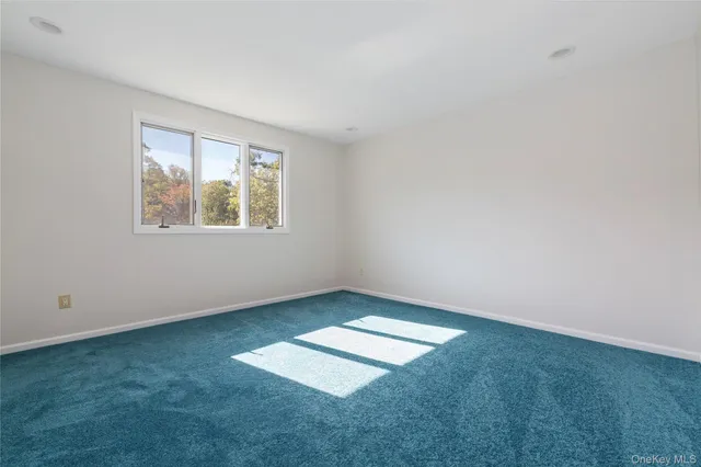 an empty room with wooden floor and ceiling fan