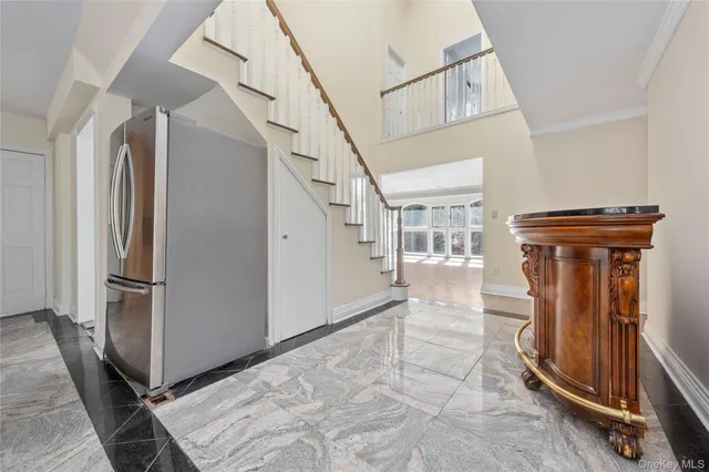 a view of a kitchen with furniture a refrigerator and large windows