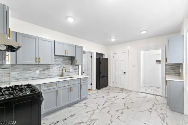 a kitchen with stainless steel appliances granite countertop a stove a refrigerator and a sink