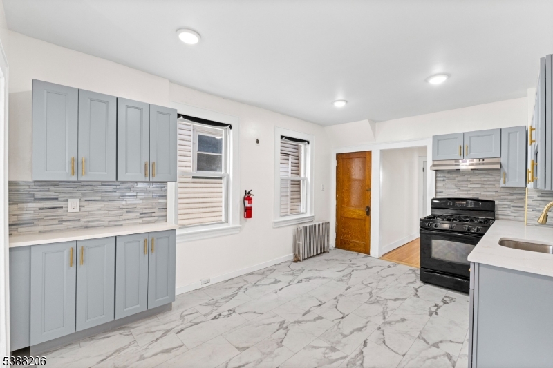 3202 Tremley Point Road Linden, NJ 07036 - Photo 17 of 41 a kitchen with stainless steel appliances granite countertop a stove a sink and a refrigerator