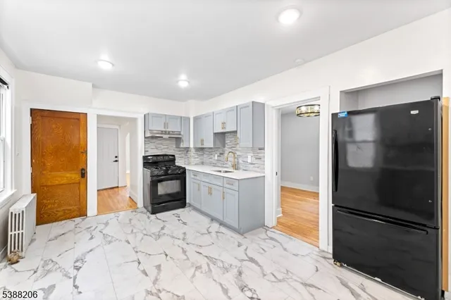 a kitchen with stainless steel appliances granite countertop a refrigerator and a sink