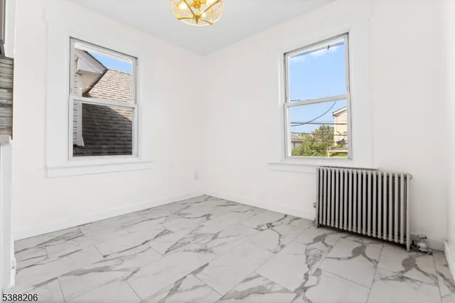 an empty room with a window and mirror