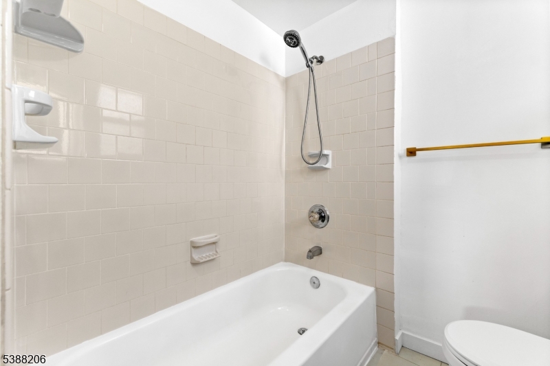 3202 Tremley Point Road Linden, NJ 07036 - Photo 29 of 41 a white bath tub sitting next to a white toilet and sink