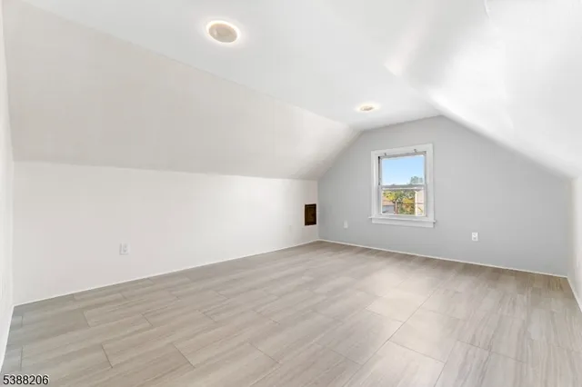 an empty room with a window and wooden floor