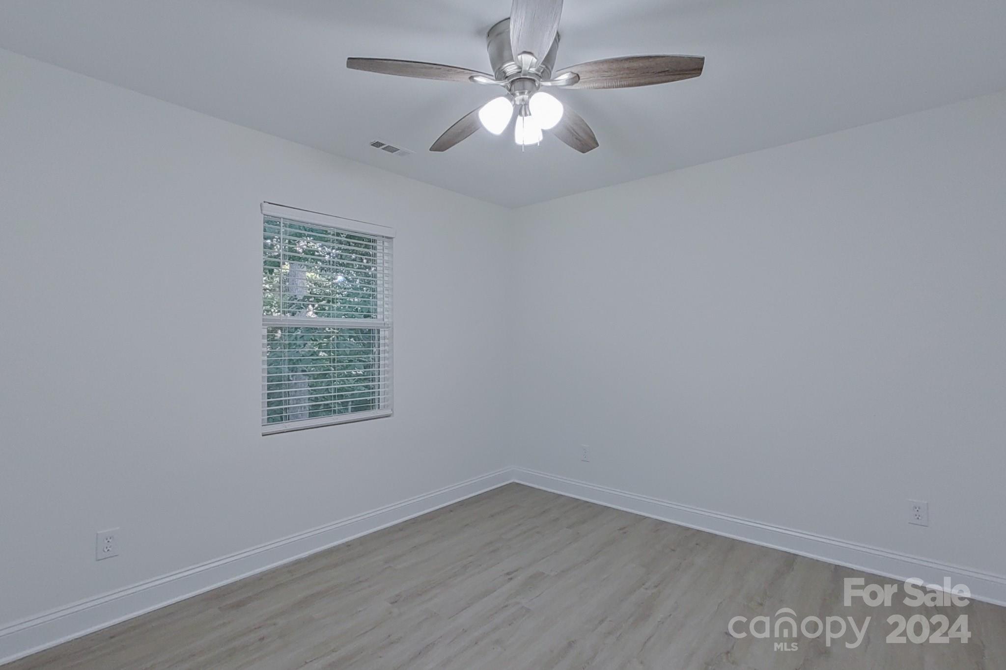 5710 Stream Ridge Drive Charlotte, NC 28269 - Photo 37 of 48 an empty room with a window and a fan
