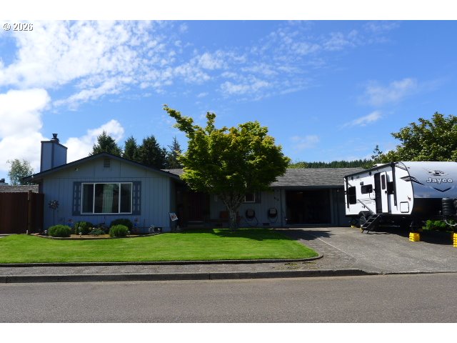 412 Camellia Court Reedsport, OR 97467 - Photo 3 of 48 a front view of a house with a garden and a yard