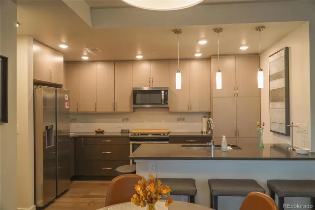 a kitchen with stainless steel appliances granite countertop a sink a stove and a refrigerator