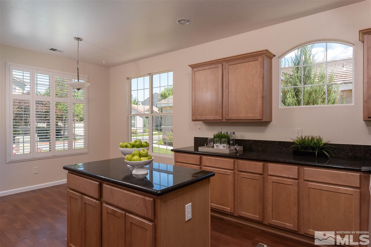 1614 Mountain Lane Reno, NV 89521 - Photo 3 of 25 a kitchen with kitchen island granite countertop a sink and white cabinets
