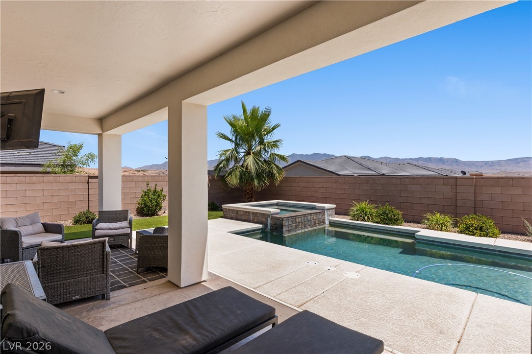1436 Manassas Ridge Mesquite, NV 89027 - Photo 46 of 77 Relax in this tranquil outdoor space, featuring a private pool and spa, set against a distant mountain backdrop.