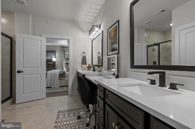 a spacious bathroom with a double vanity sink a mirror and a bathtub