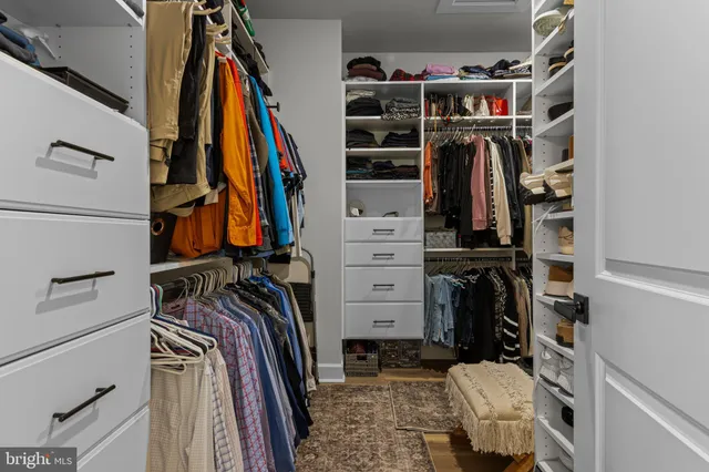 a view of walk in closet with clothes and shoes