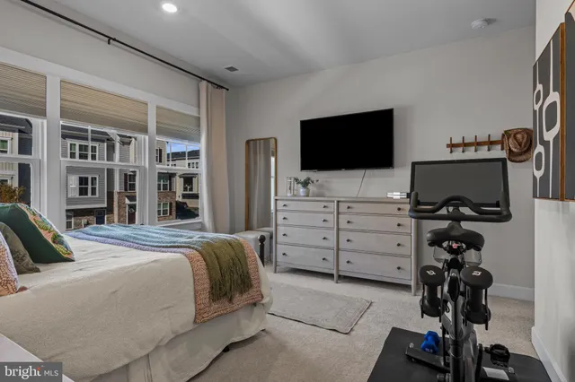 a bedroom with a bed and a flat tv screen on dresser