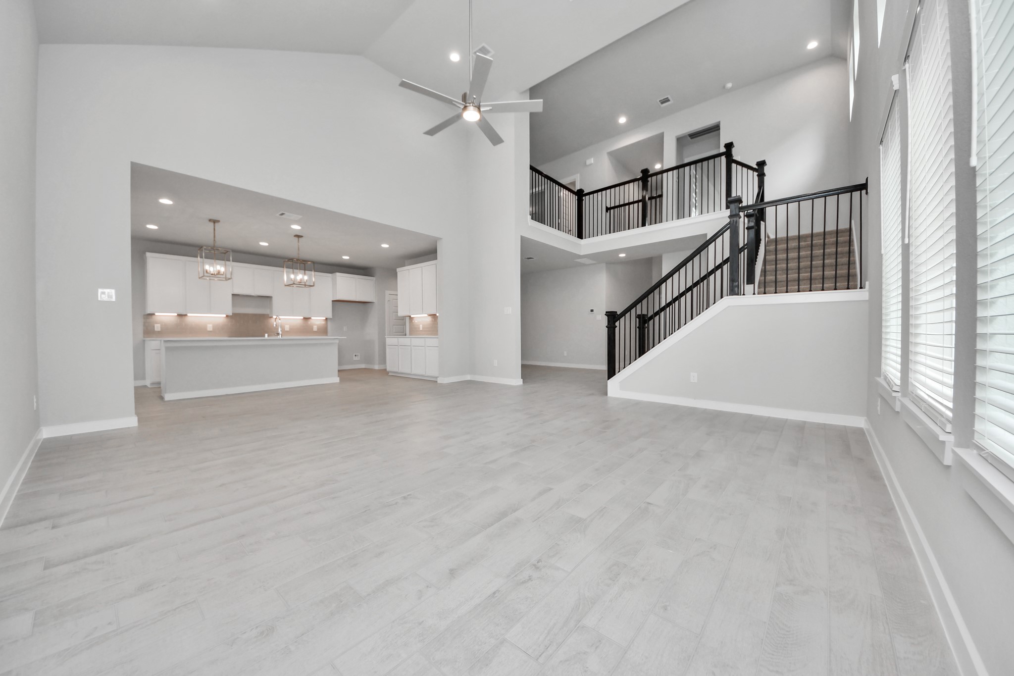 11114 Tulip Rdg Trail Houston, TX 77044 - Photo 14 of 30 Welcome family and guests to your charming living room! With its high ceilings, recessed lighting, ceiling fan, custom paint, beautiful flooring, and large windows that let in abundant natural light, this room is perfect for gatherings. Sample photo of completed home with similar floor plan. Actual colors and selections may vary.