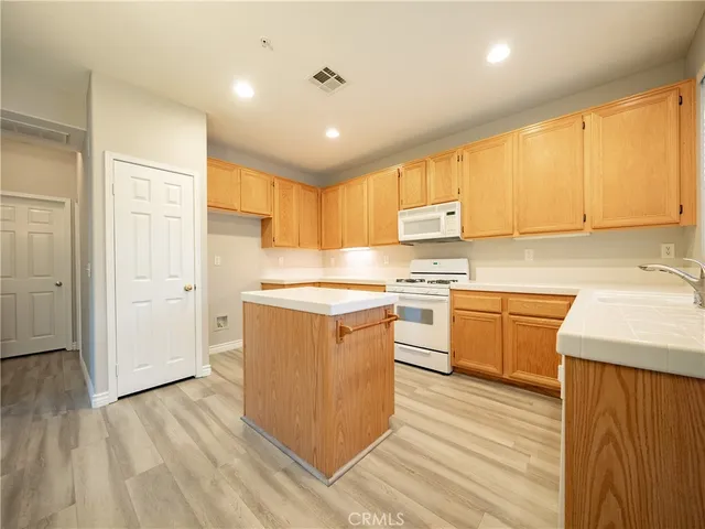 a kitchen with granite countertop a sink cabinets and wooden floor