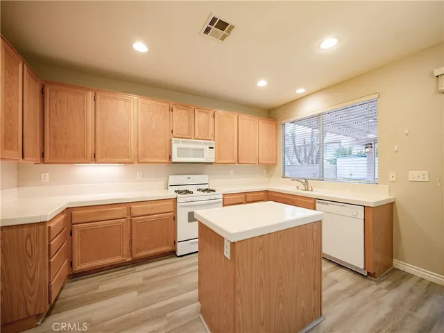 a kitchen with stainless steel appliances granite countertop a stove a sink dishwasher and a refrigerator
