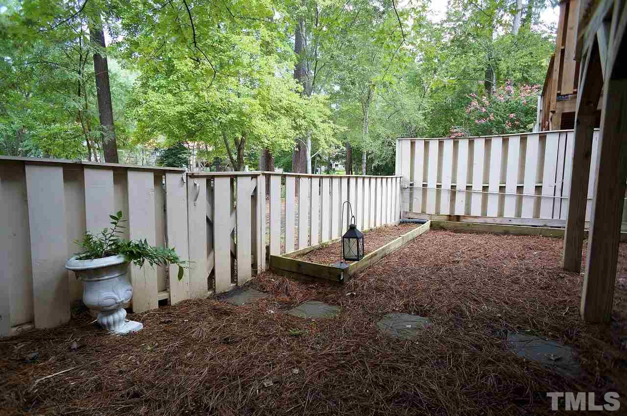 5803 Mapleridge Road Raleigh, NC 27609 - Photo 21 of 23 a view of a backyard with swing plants and wooden fence