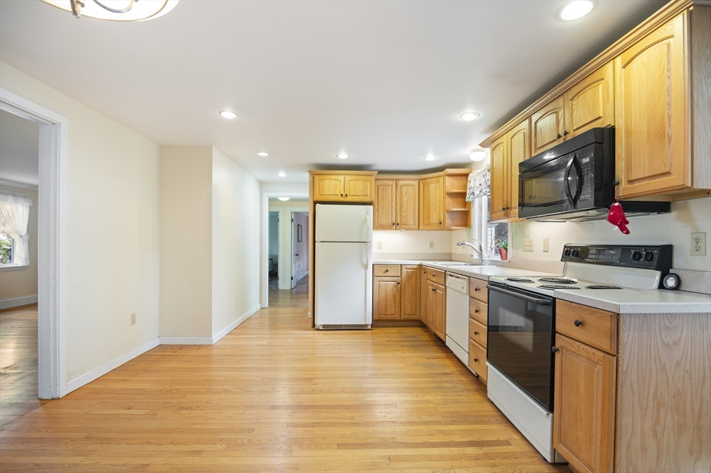 110 Linden Street Hamilton, MA 01982 - Photo 7 of 25 a kitchen with stainless steel appliances granite countertop a sink cabinets and wooden floor