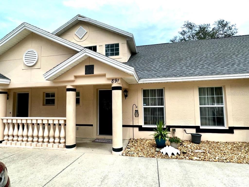 891 East Rembrandt Way Inverness, FL 34453 - Photo 1 of 27 a front view of a house with a garage