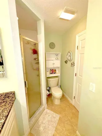 a bathroom with a granite countertop toilet and a shower