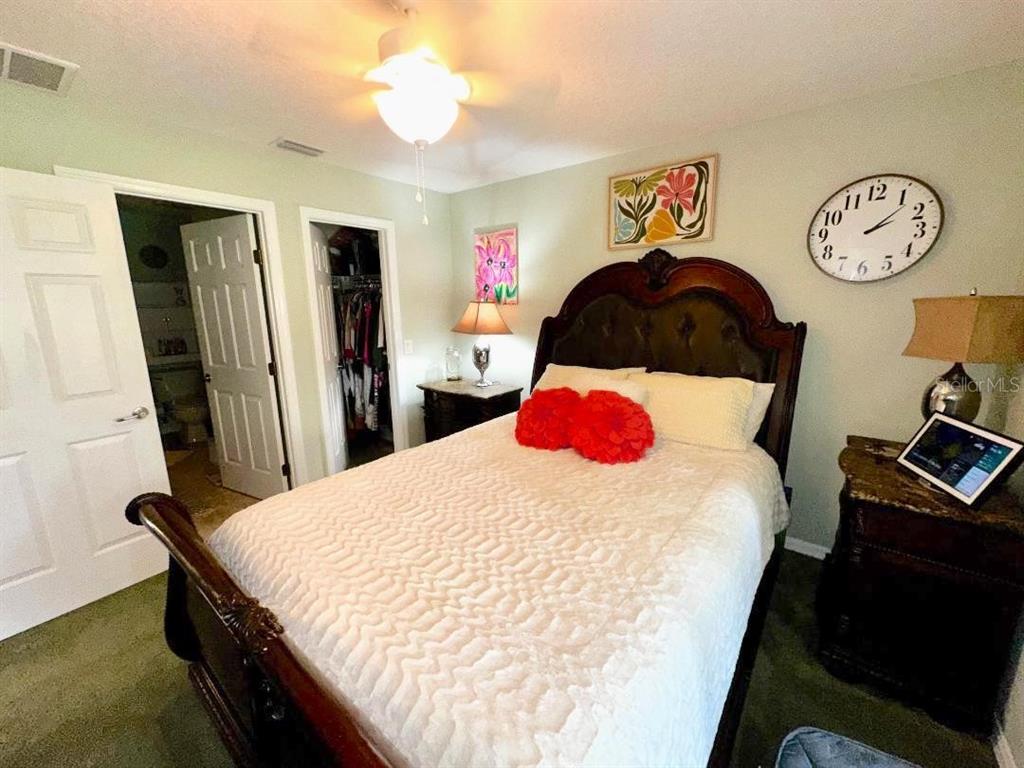 891 East Rembrandt Way Inverness, FL 34453 - Photo 14 of 27 a bedroom with a bed and a lamp on dresser