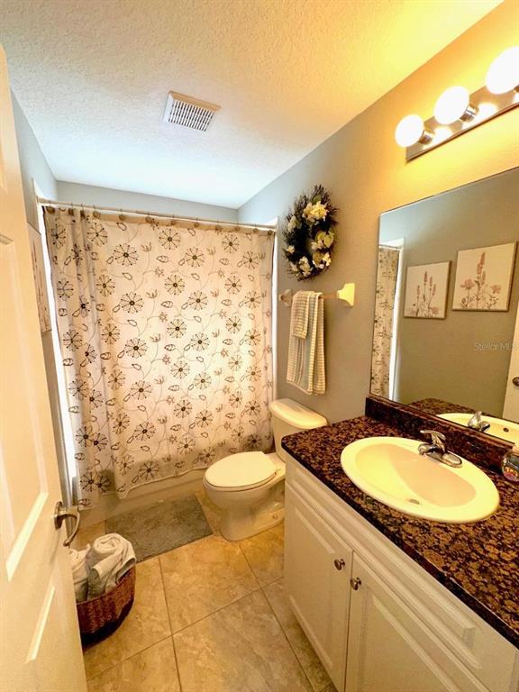 891 East Rembrandt Way Inverness, FL 34453 - Photo 18 of 27 a bathroom with a granite countertop sink toilet a mirror and shower curtain