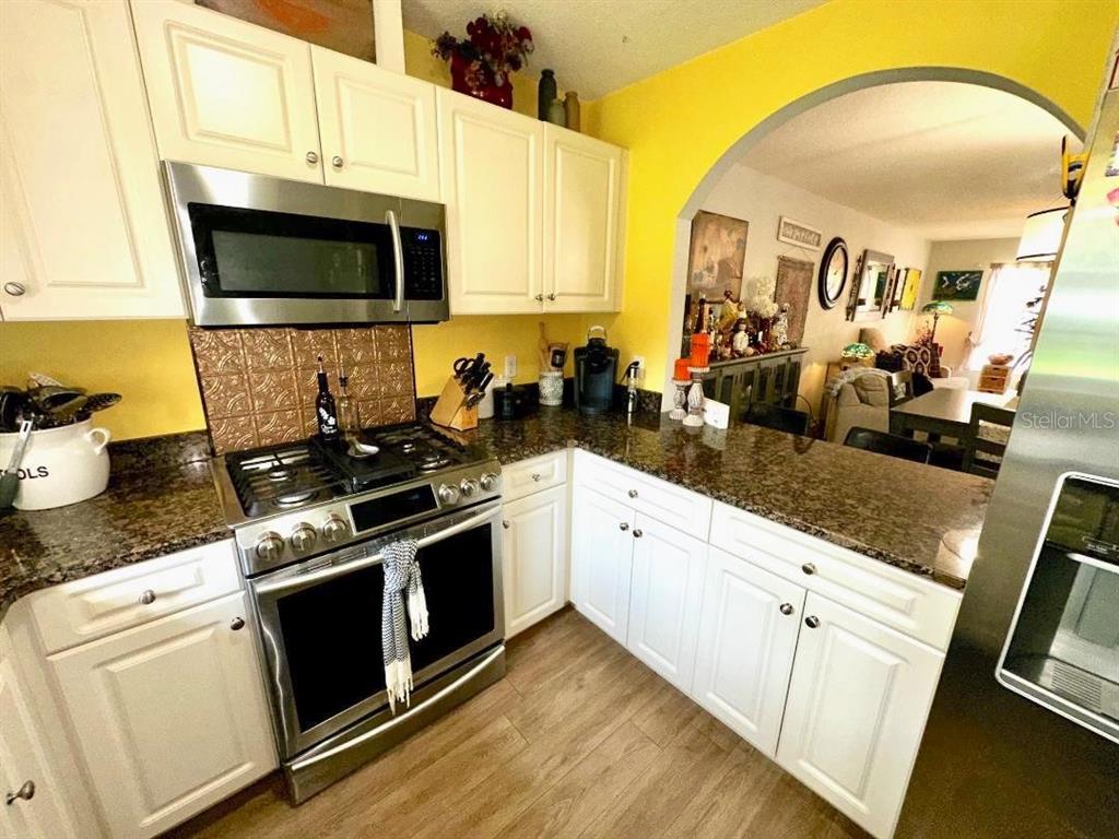 891 East Rembrandt Way Inverness, FL 34453 - Photo 19 of 27 a kitchen with stainless steel appliances a stove microwave and sink