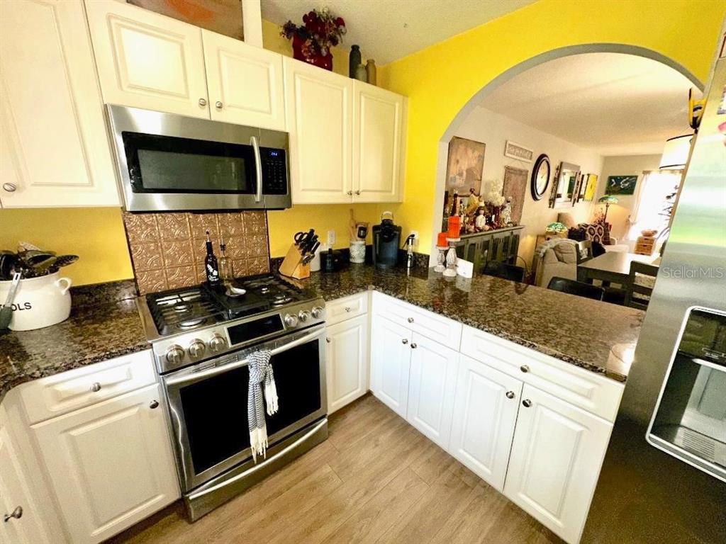 891 East Rembrandt Way Inverness, FL 34453 - Photo 24 of 27 a kitchen with stainless steel appliances a stove microwave and sink