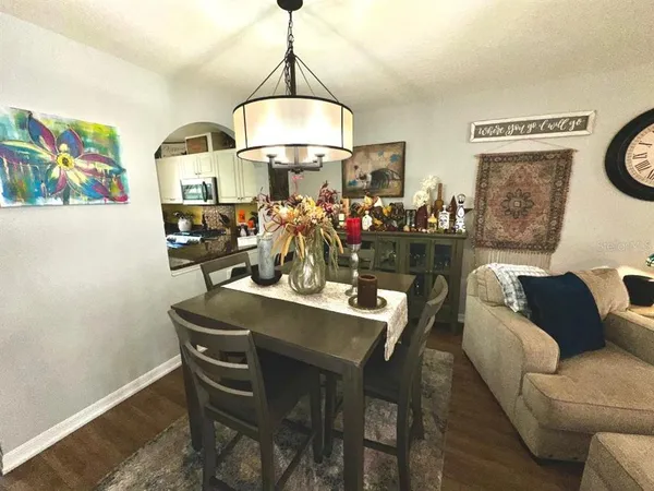 a view of a dining room with furniture a chandelier and wooden floor