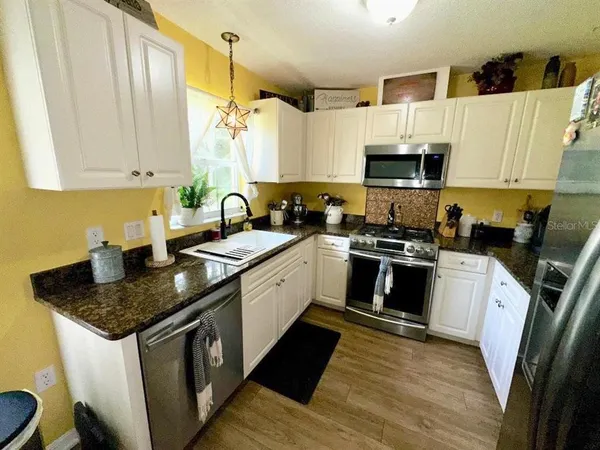 a kitchen with a sink stove and microwave