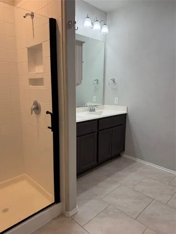 a bathroom with a double vanity sink a mirror and a shower