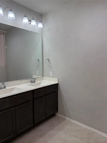 a bathroom with a sink vanity and a mirror