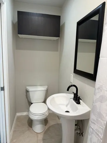 a bathroom with a toilet a sink and mirror
