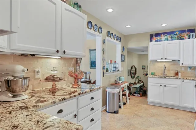 a kitchen with granite countertop a sink a stove and a refrigerator