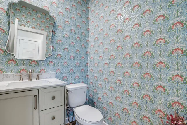 a bathroom with a sink a toilet and a mirror