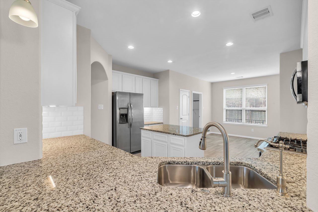 14304 Prospect Park Lane Conroe, TX 77384 - Photo 14 of 38 a kitchen with stainless steel appliances granite countertop a sink and a refrigerator