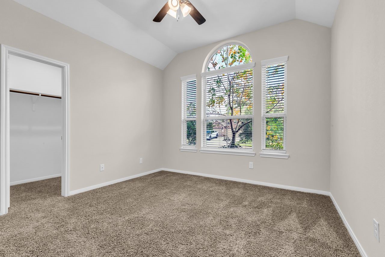 14304 Prospect Park Lane Conroe, TX 77384 - Photo 17 of 38 an empty room with windows and chandelier fan