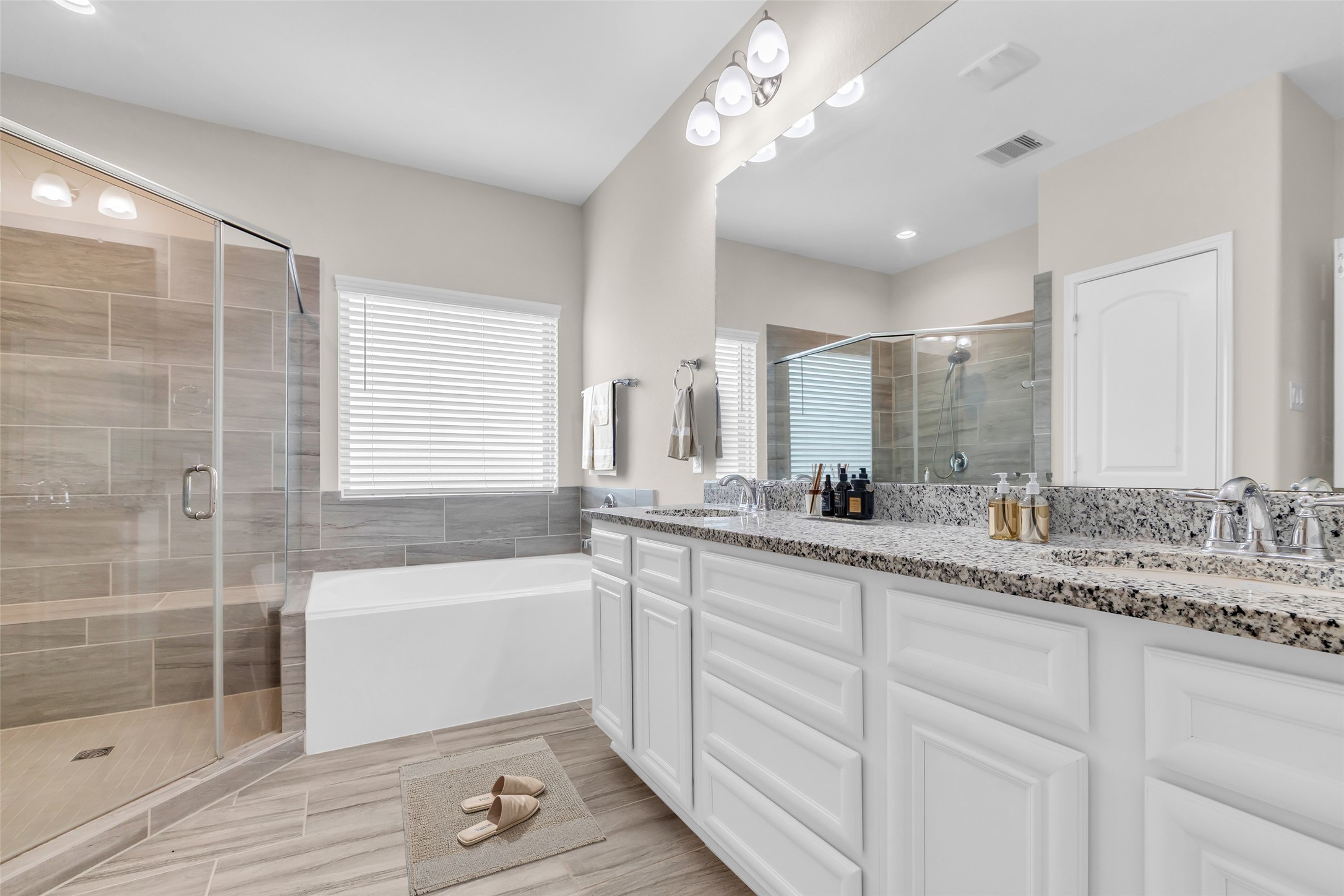 14304 Prospect Park Lane Conroe, TX 77384 - Photo 26 of 38 a bathroom with a granite countertop double vanity sink a mirror and a bathtub