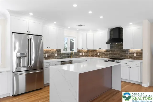 a kitchen with stainless steel appliances a refrigerator and a stove top oven