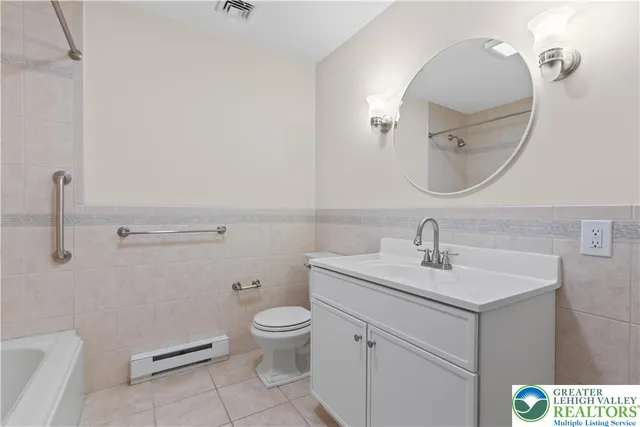 a view of an empty room with wooden floor fireplace and a window