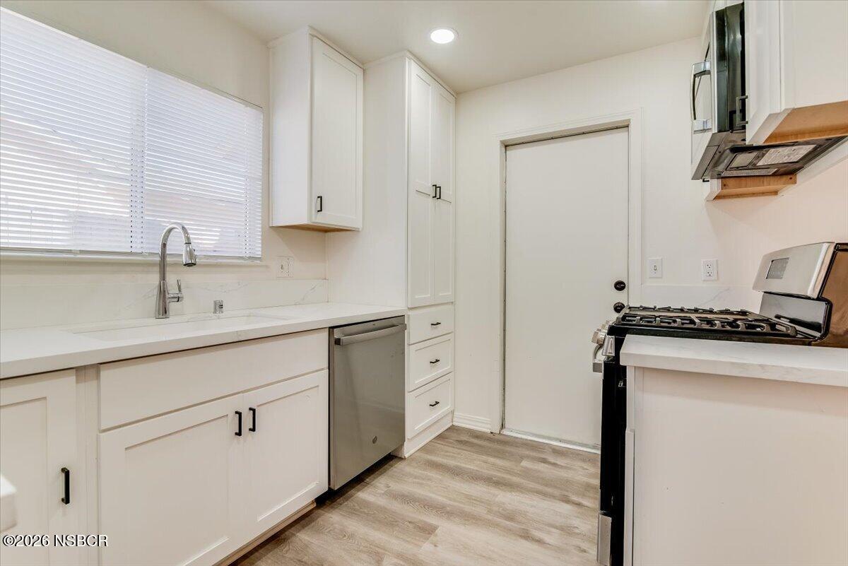 321 North Z Street Lompoc, CA 93436 - Photo 10 of 33 a kitchen with white cabinets and a sink