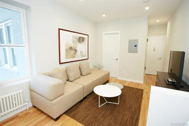a living room with furniture a wooden floor and a flat screen tv